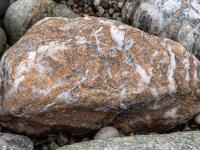 Rötlichgrauer Stein mit weißen Einschlüssen